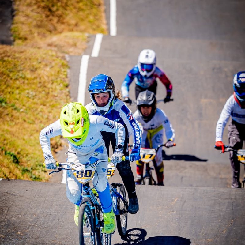 Grupo de pilotos de BMX compitiendo en una pista de peralte azul