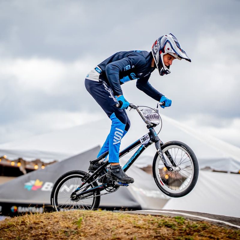 Piloto con jersey Four Straights acelerando en una pista de BMX